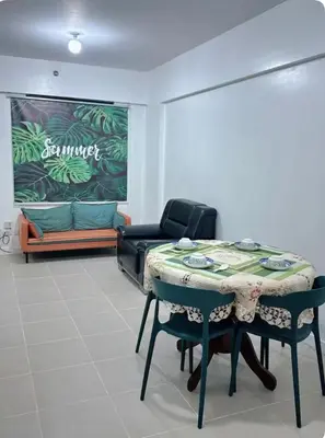 a room with a table and chairs and a couch at Mid-rise staycation in parañaque in Manila