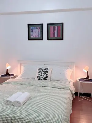 a white bedroom with a bed with two lamps at Place to stay in pasay near Airport in Manila