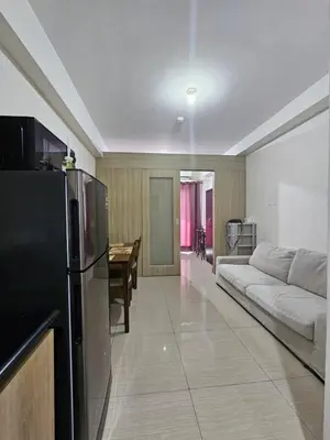 a living room with a couch and a refrigerator at Shore Residences Sm Mall of Asia Caitlin in Manila