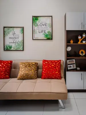 a couch in a living room with three pictures on the wall at The Bat Cave 3 at Coast Residences Pasay in Manila