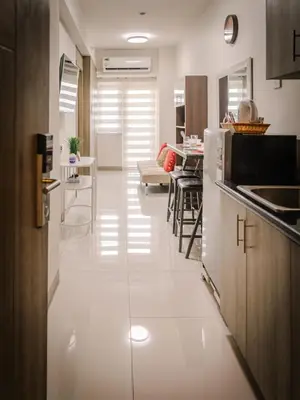 a kitchen with white flooring and a dining room at The Bat Cave 3 at Coast Residences Pasay in Manila