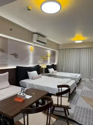 a room with two beds and a table and chairs at Modern Boutique Spacious Apartment Near Airport OKADA SOLAIRE MOA in Manila