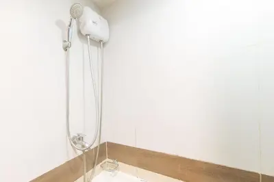 a shower in a bathroom with a shower head at RedDoorz Premium at MyTown New York in Manila