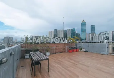 a balcony with a table and a view of a city at RedDoorz Premium at MyTown New York in Manila