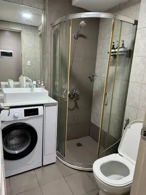 a bathroom with a shower and a toilet and a sink at Monarch Parksuites staycation near Moa IKEA Solaire in Manila