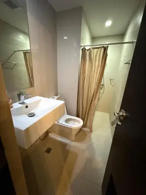 a bathroom with a toilet and a sink and a shower at The Cozy Rustic in General Trias