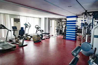 a gym with several treadmills and machines in a room at Air Bel & Be! Your space, Your calm, Your comfort in Manila