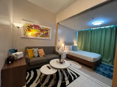 a small living room with a couch and a bed at 1BR - Uptown BGC Taguig in Manila