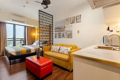 a kitchen and a living room with a couch and a bed at Opulent Condo Knightsbridge Residences in Manila