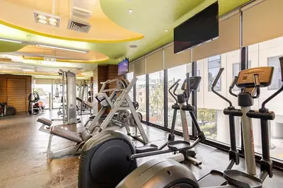 a gym with several tread machines and a flat screen tv at Opulent Condo Knightsbridge Residences in Manila