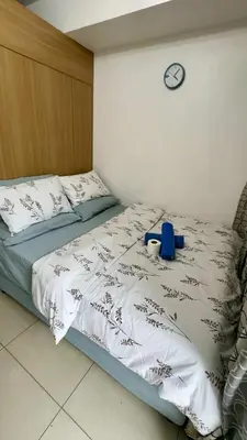 a bedroom with a bed with a clock on the wall at Shell Residence MOA Pasay by Kathy in Manila