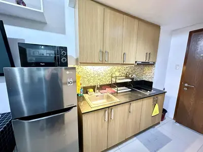 a kitchen with a stainless steel refrigerator and a sink at Shell Residence MOA Pasay by Kathy in Manila