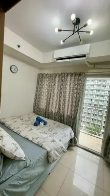 a bedroom with a bed and a large window at Shell Residence MOA Pasay by Kathy in Manila