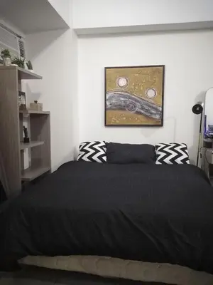 a bedroom with a black bed and a painting on the wall at Venice Mall Area Mckinley Hills Taguig in Manila