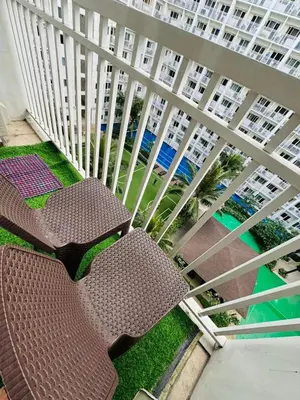 two brown chairs on a balcony with a building at Shore 1br shortwalk mall of asia in Manila