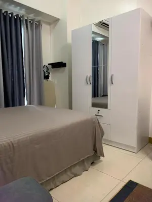 a bedroom with a bed and a large mirror at Comfy Studio near Southmall Las Piñas in Manila