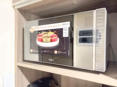a microwave on a shelf with a bowl of desserts at The Luxe Haven at BGC in Sampong