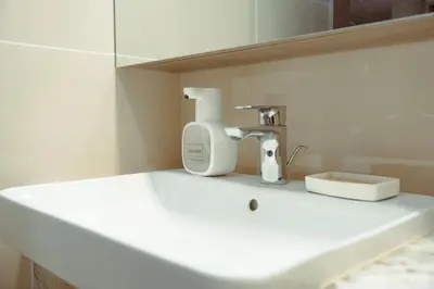 a white sink with a hair dryer and a mirror at The Luxe Haven at BGC in Sampong