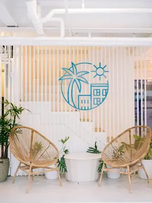 two chairs and a sign on a wall with plants at Canopyproperties in Manila