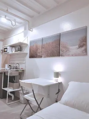 a white bedroom with a desk and a bed at Canopyproperties in Manila