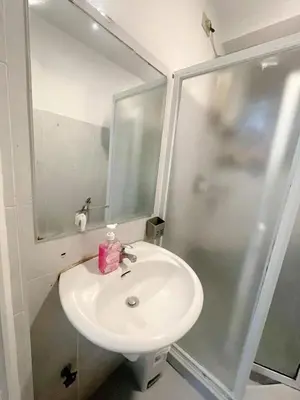 a bathroom with a white sink and a shower at Staycation 2 Bedroom at Sea Residences Pasay across Mall of Asia near NAIA Airport in Manila