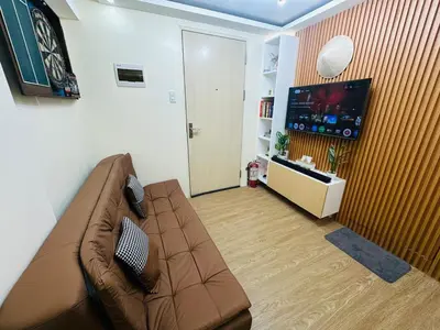 a living room with a couch and a flat screen tv at 17th Casa Horizon in Manila