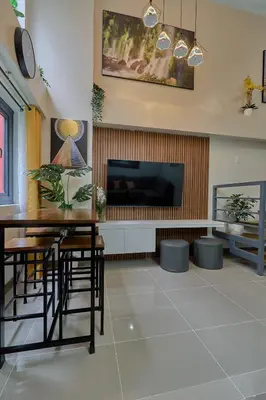 a living room with a table and a tv at Modern Loft-Style Condo - Perfect for Families or Couples in Manila