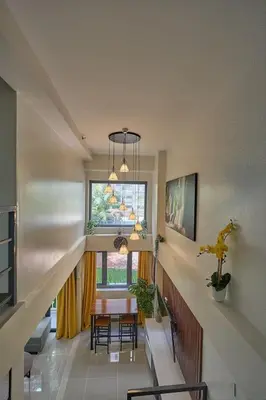 a room with a staircase with a table and a window at Modern Loft-Style Condo - Perfect for Families or Couples in Manila