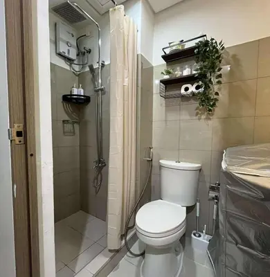 a small bathroom with a toilet and a shower at Cozy Haven in Manila