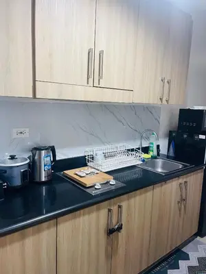 a kitchen with a counter top with a sink and a counter top at 1 bedroom near MOA NAIA with parking slot included pls send valid ids of guests after booking in Manila