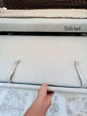 a person reaching for a mattress on a bed at Sarah's Place at Light Residences in Manila