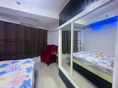a bedroom with two bunk beds and a red chair at Ritzy Pasay Getaway - Entire Apartment for Rent in Manila