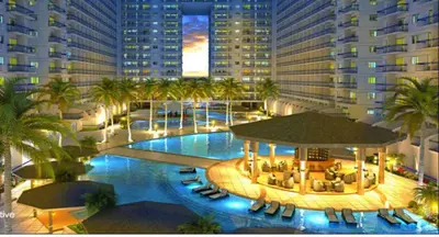 an overhead view of a large pool with palm trees and buildings at Ritzy Pasay Getaway - Entire Apartment for Rent in Manila
