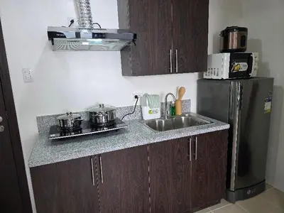a kitchen with a sink and a refrigerator at 2 BR Penthouse with Sunset View in Manila