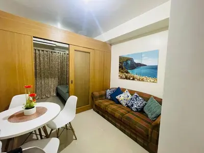 a living room with a couch and a table at Elegant Pasay City Apartment with Central Heating Shared Pool in Manila