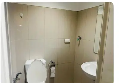 a bathroom with a toilet and a sink at Elegant Pasay City Apartment with Central Heating Shared Pool in Manila