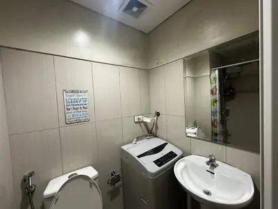 a bathroom with a sink and a toilet and a mirror at Simple Pasay Getaway - Entire Apartment for Rent in Manila