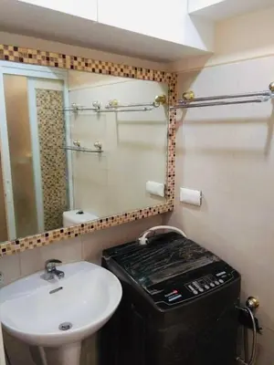 a bathroom with a sink and a mirror at Charming 1-Bedroom Apartment in the Heart of Pasay City in Manila