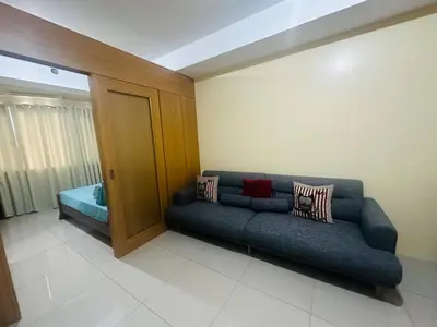 a living room with a blue couch in a room at Timeless Pasay City Apartment for Rent in Manila