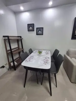 a table and chairs in a room with a couch at idyllic Apartment for Rent - Perfect for Short-Term Stay Front of Mall of Asia in Manila