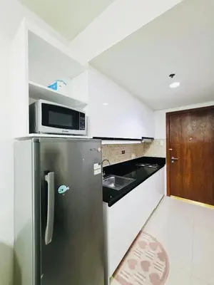 a small kitchen with a refrigerator and a microwave at idyllic Apartment for Rent - Perfect for Short-Term Stay Front of Mall of Asia in Manila