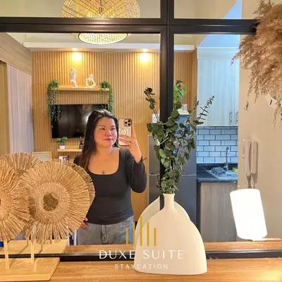 a woman taking a picture of herself in a mirror at Staycation in RLX in Manila