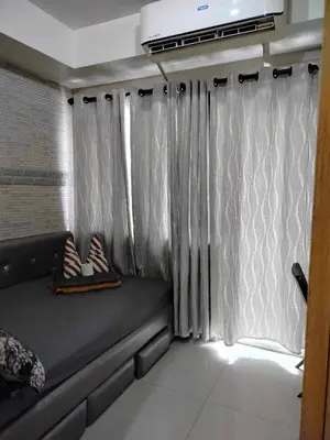 a room with a bed and a window with curtains at Peaceful Pasay Oasis - Entire Apartment for Rent in Manila