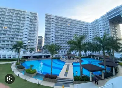 a large swimming pool in front of a large building at Peaceful Pasay Oasis - Entire Apartment for Rent in Manila