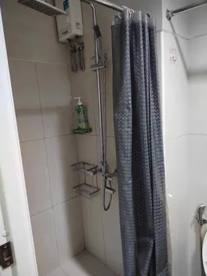 a shower with a shower curtain in a bathroom at Peaceful Pasay Oasis - Entire Apartment for Rent in Manila