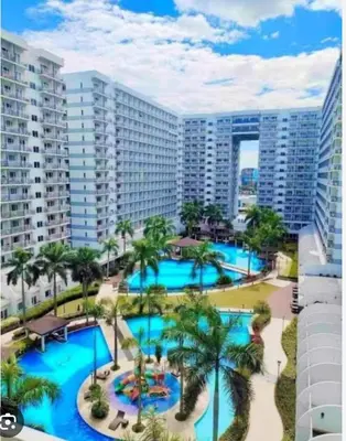 an aerial view of a resort pool with palm trees at Peaceful Pasay Oasis - Entire Apartment for Rent in Manila