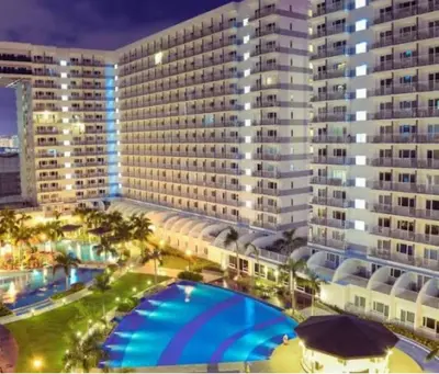 a large building with a large pool in front of it at Dainty Pasay City Apartment for Rent - Entire House Front of Mall of Asia in Manila