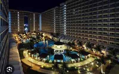 a large building with a large pool in front of it at Dainty Pasay City Apartment for Rent - Entire House Front of Mall of Asia in Manila