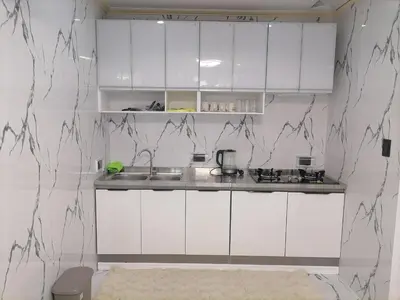 a kitchen with white cabinets and a counter top at Navio Transient House in Cabuyao