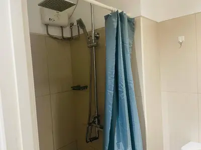 a shower with a blue shower curtain in a bathroom at Fancy Pasay City Apartment for Rent - Mall of Asia Nearby front of Mall Of Asia in Manila